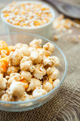 A bowl of popcorn on a wooden table, caramel popcorn