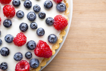 Cake with blueberries and raspberries. Confectionery product.