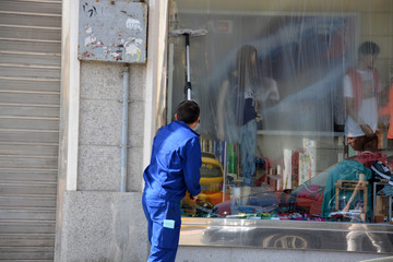 hombre limpiando un escaparate