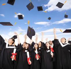 happy students throwing graduation caps into the Air