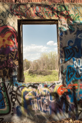 Graffiti covered wall and window to landscape