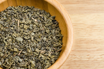 green tea, dried leaves, on wooden background