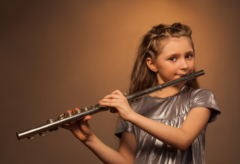 View of girl with long hair playing on flute