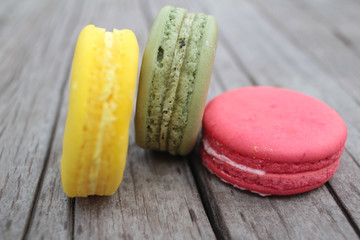Macaroons colorful delicious on wood background.