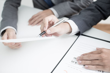 Two businessmen looking at report and having a discussion in off