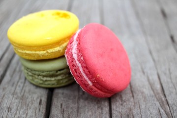 Macaroons colorful delicious on wood background.