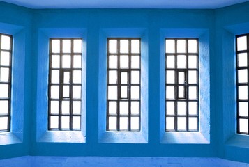Abstract view of symmetrical windows on blue wall