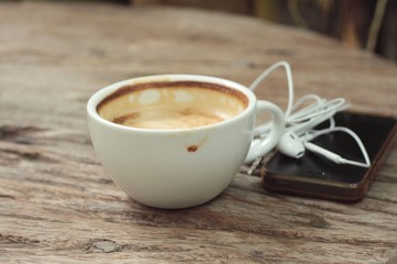 latte coffee in cup on wood background and smart phones