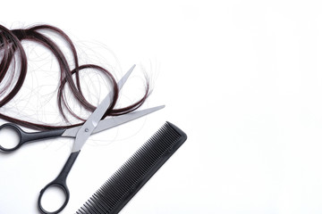 Scissors and comb with brown hair isolated left