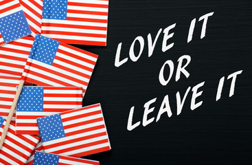 Obraz premium The phrase Love It or Leave It on a blackboard with USA flags