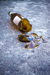Shattered brown beer bottle resting on the ground