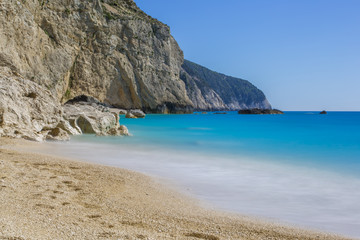 Sand beach with blue sea, blue sky and rocks