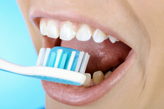 Frau putzt Zähne mit Zahnbürste