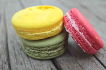 Macaroons colorful delicious on wood background.