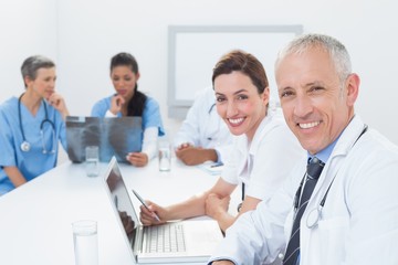 Team of doctors working on laptop and analyzing xray