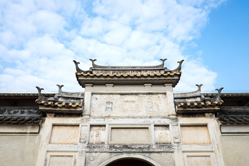 Naklejka premium Looking up at antique chinese gate with blue sky