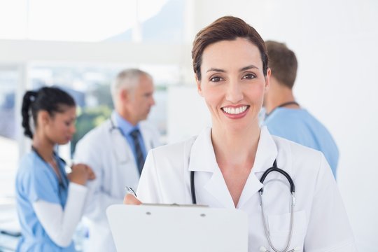 Confident female doctor holding clipboard