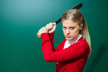 Angry student with baseball bat in front of blackboard