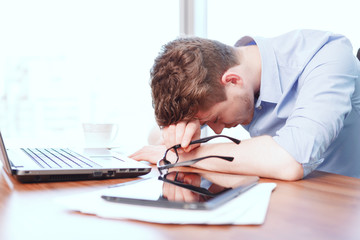 Young businessman sleeping on desk