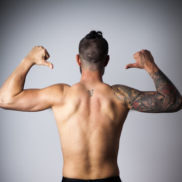 Espalda de hombre con brazo tatuado