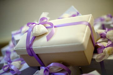 Pacchetto regalo per bomboniera con fiocco viola in primo piano