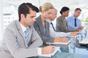 Business team taking notes during conference 