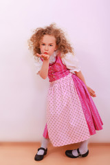 Blonder Lockenkopf im Dirndl, wirft einen Kuss zu