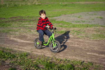 little boy rides a bicycle