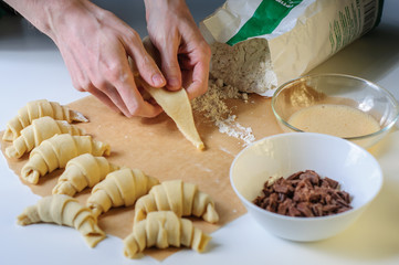 Croissants cooking on white table with flour and baking paper