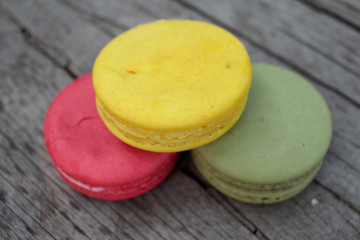 Macaroons colorful delicious on wood background.