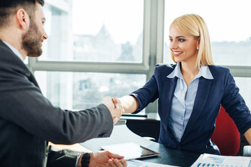Businesswoman and businessman handshake in the office