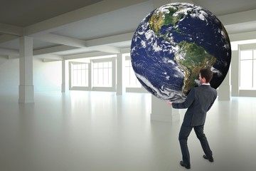 Composite image of businessman carrying the world