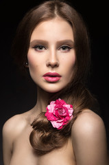 Fototapeta na wymiar Beautiful girl with pink lips and a rose in her hair.