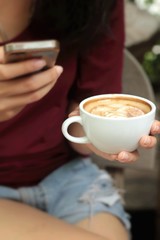 Woman drinking coffee in cup and smart phones