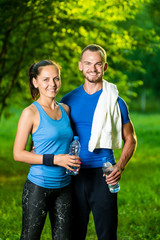 Fototapeta premium Man and woman drinking water from bottle after fitness sport