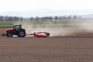 Fototapeta premium Tractor harrowing the field