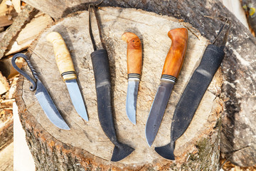 hand made knives on tree stump