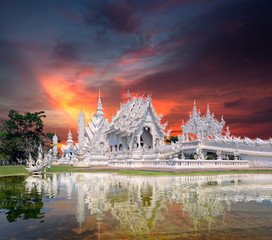 sunset time White temple Wat thai name "Wat Rong Khun" landmark of Chiang rai province art and culture of Thai beautiful place amazing landscape, reflection of water, traveler tourist around the world