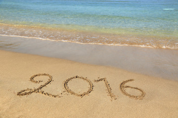Fototapeta na wymiar 2016 written on sandy beach