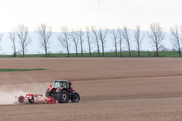 Fototapeta premium Tractor harrowing the field