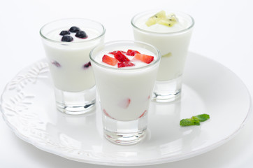 three yogurt with fruit in a glass beaker horizontal