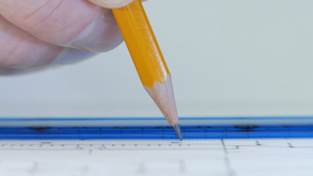 Drawing a pencil line on the ruler on the drawing sheet