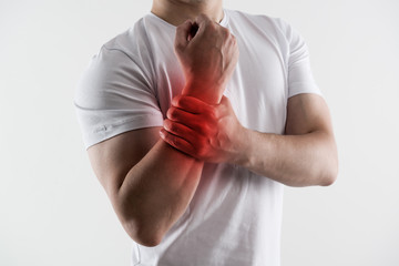 Man with broken wrist. Young male massaging injured hand.