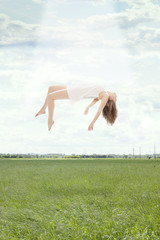 Young beautiful woman floating towards the sky