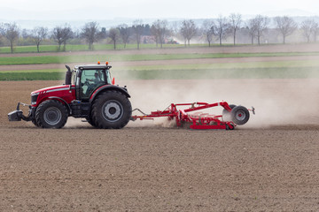 Obraz premium Tractor harrowing the field