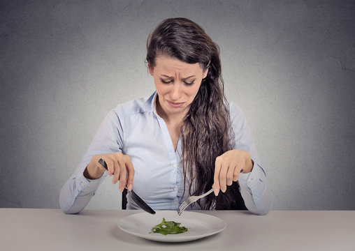 woman tired of diet restrictions eating green salad