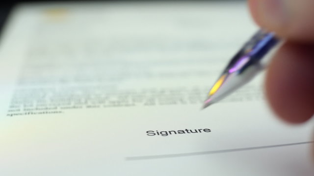 Pen signing a document