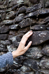 Touching the stone wall women hand