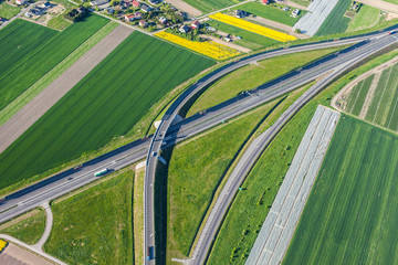 aerial view of highway and green harvest fields