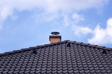 Naklejka premium Orange chimney on tiled roof